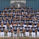 Carey High School Blue Devils football players standing on stadium seats with the "Carey Blue Devil" logo prominently displayed behind them.