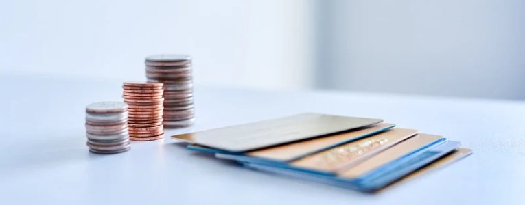 Coins and visa cards are placed on table