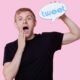 Portrait of surprised young man holding tweet bubble against pink background