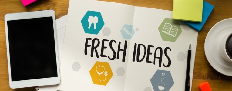 An image of a book with 'Fresh Ideas' written on it, a tablet placed on the left side, and a pen on the right side.